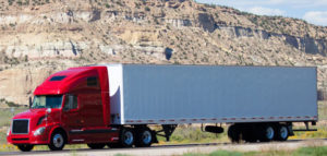 18-wheeler with a red cab on a highway