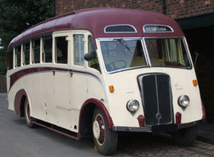 restored white 1930's flat-front bus with a red roof