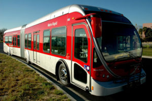 red articulated bus on a city street