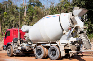 a cement truck with a red cab at a construction site