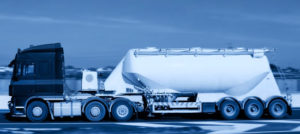 a side view of dry bulk truck traveling on a winter road