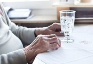 elderly patient looking at a glass of water on the table is a familiar sight for a nursing home dehydration lawyer