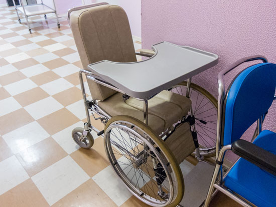 a wheelchair with a tray that can restrain a patient requiring the help of a nursing home physical restraint lawyer