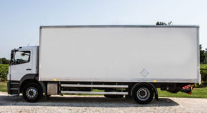 side view of a parked rigid truck with a white cab