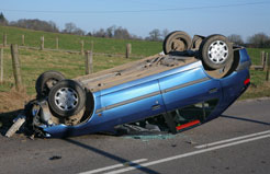 rolled over blue hatchback on a country road