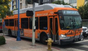 orange single-decker bus stopped at an intersection