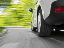 a speeding white car on a winding road