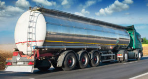 the back view of a shiny polished tanker truck on a highway