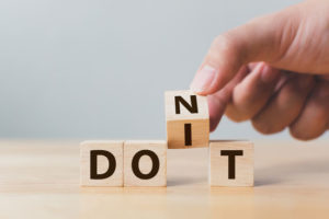 a man holding dice with letters in doubt whether to say do it or don't