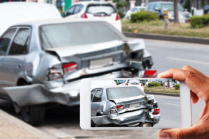 a person taking a photo of car damage after an accident with a smartphone