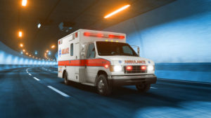 an ambulance with lights on rushing through a tunnel