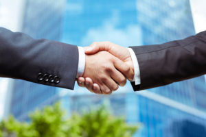 two men in suits shaking hands