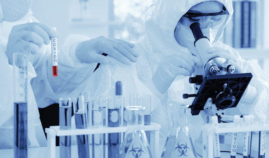 scientists in protective gear in a lab during COVID-19 vaccine clinical trials